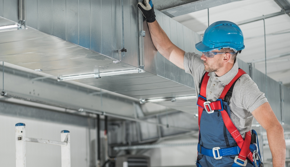 HVAC Supervisor Conducting Final Check on Modern Air Circulation System in Warehouse in New Orleans