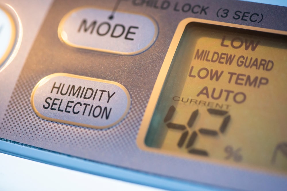 Air purifier and dehumidifier with humidity control settings. Close-up of the device displaying humidity percentage.