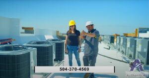 Authentic Air technicians on a rooftop, Hvac New Orleans provider consulting over HVAC units in New Orleans, with a clear blue sky in the background.